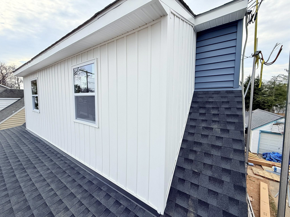 Close-up of new white vertical and blue horizontal siding on a house by High Quality Exteriors in Rockville, MD.