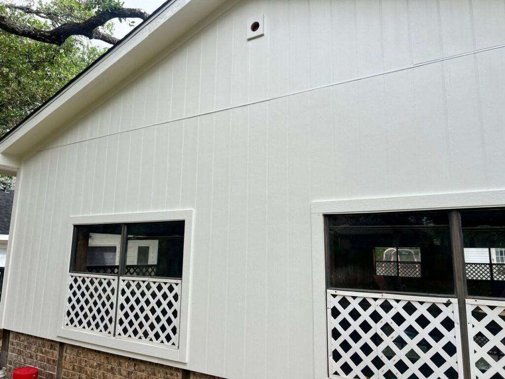 A house with modern white vertical siding and windows, a completed project by Ideal Siding Austin in Austin, TX.