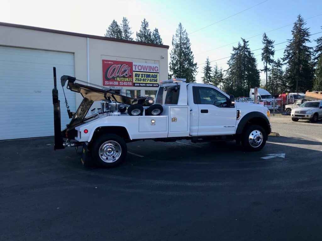 A white wrecker tow truck from Al's Towing parked outside the business in Jackson, NJ