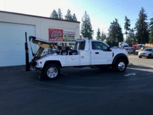 A white wrecker tow truck from Al's Towing parked outside the business in Jackson, NJ