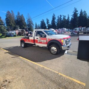A white wrecker tow truck from Al's Towing parked on a sunny day in Jackson, NJ