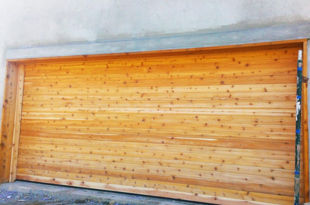 A wide natural wood garage door, showcasing a completed installation by Mark's Garage Door Services in Santa Fe, NM.