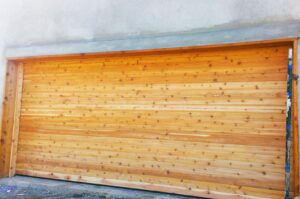 A wide natural wood garage door, showcasing a completed installation by Mark's Garage Door Services in Santa Fe, NM.