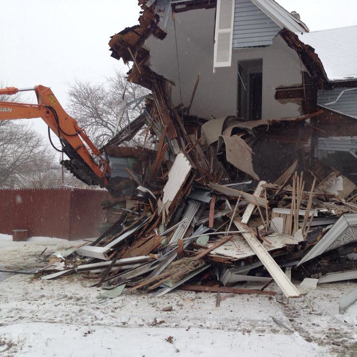 An excavator from Just Take It, LLC. performing a house demolition job in winter conditions in Yorba Linda, CA.