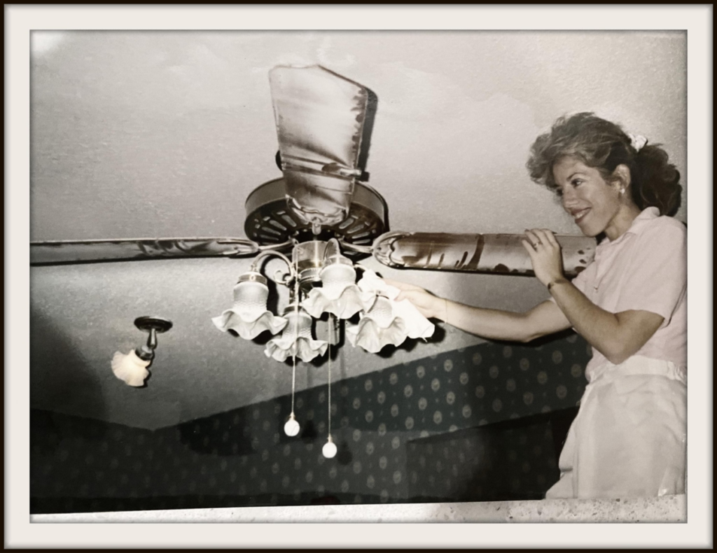 A woman cleaning a ceiling fan, demonstrating a house cleaning service by Cleaning For A Reason - Official Page in Rosemont, IL.