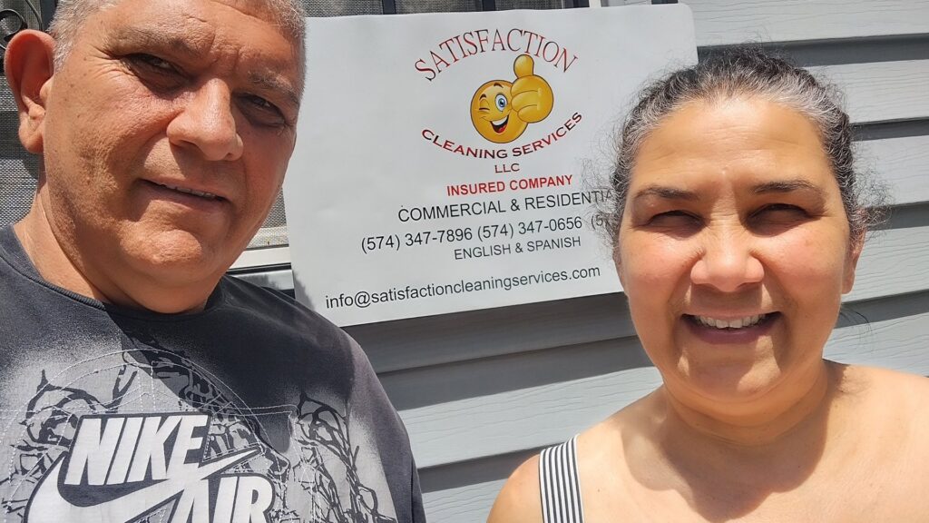 A woman cleaning the exterior of a house with a long-handled brush for Satisfaction Cleaning in Athens, AL.