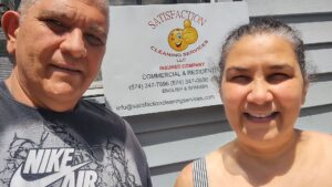 A woman cleaning the exterior of a house with a long-handled brush for Satisfaction Cleaning in Athens, AL.