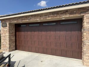 A residential home with a stylish brown wood-grain garage door, installed by Quality-Brand Garage Doors in Rio Rancho, NM.