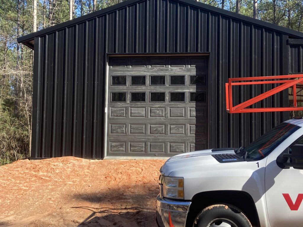 Installation of a wood-look garage door on a metal building by Jonathan at Verge Entrance Solutions/Overhead Door in Hattiesburg, MS.