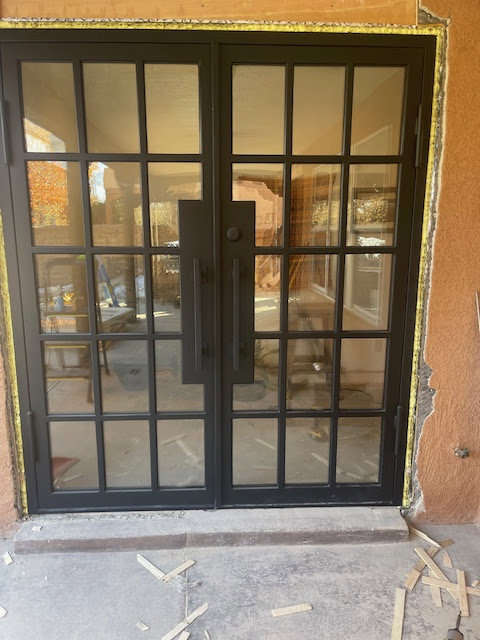 A beautiful wooden double garage door with decorative studs, expertly installed by Door Man LLC in Albuquerque, NM.
