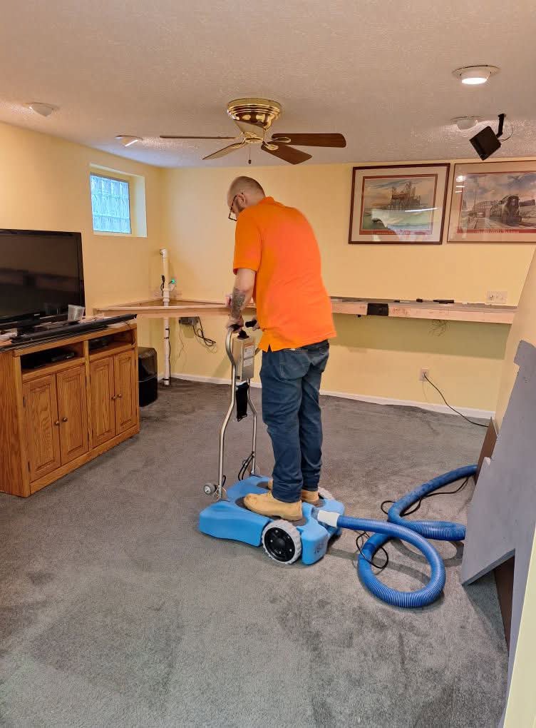 A worker operating a professional carpet water extraction machine for Flood Force in Dayton, OH.