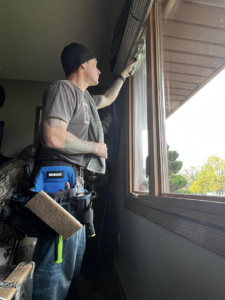 A worker from Rocket Window Cleaning in Lincoln, NE, cleaning an interior window of a residential home.