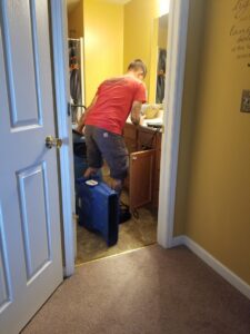 A Quick Response technician uses a powerful air mover to dry a bathroom after water damage in Las Vegas, NV.