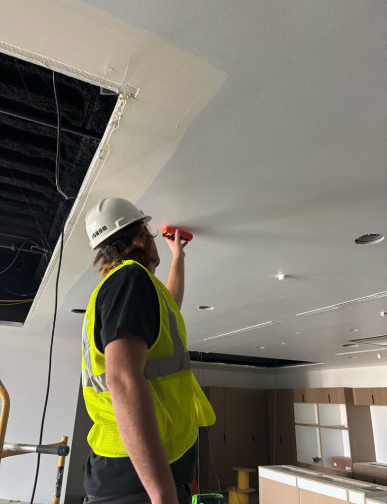 A Servpro of Sandy technician inspecting a ceiling for moisture damage in Sandy, UT.