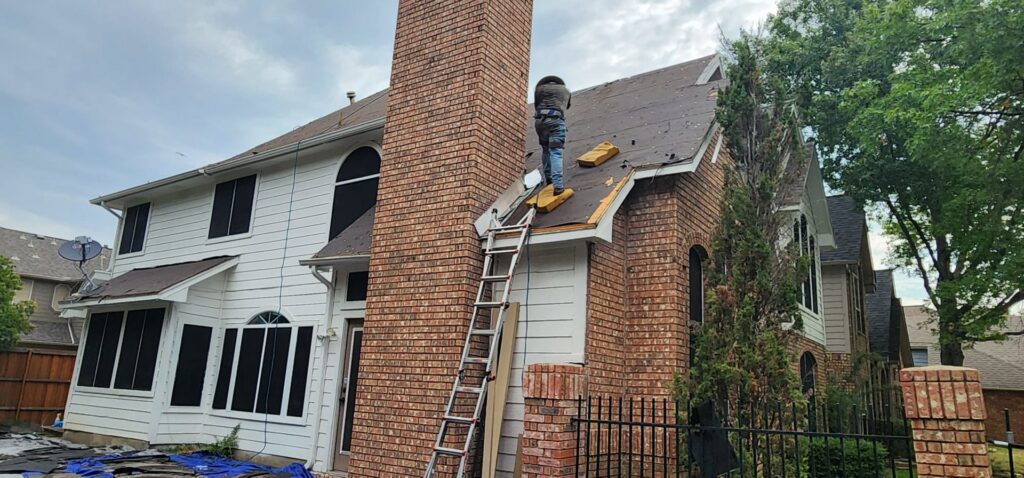 A worker on a ladder installing new siding panels on a house by Home Quality Solutions,LLC in Old Orchard Beach, ME