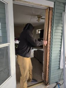 A worker from Grand Rising Group removing a water-damaged door frame during a restoration project in Mitchell, SD.