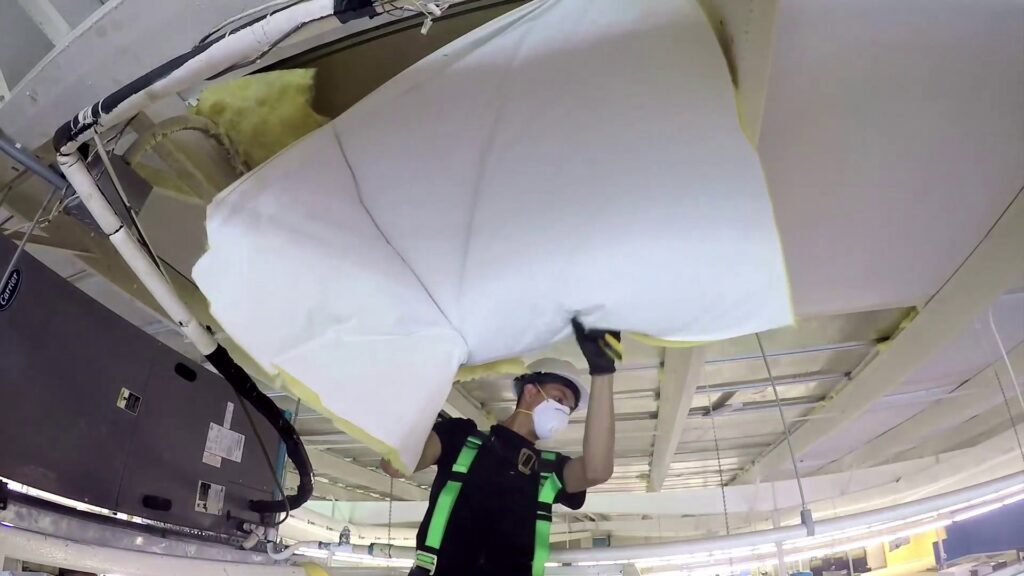 A SERVPRO of South Shreveport worker removing damaged ceiling materials, likely wet insulation, during a restoration job in Shreveport, LA.