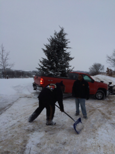 A worker shoveling snow from a residential driveway for Haynes Snow Removal & Lawn Maintenance in Madison, WI.