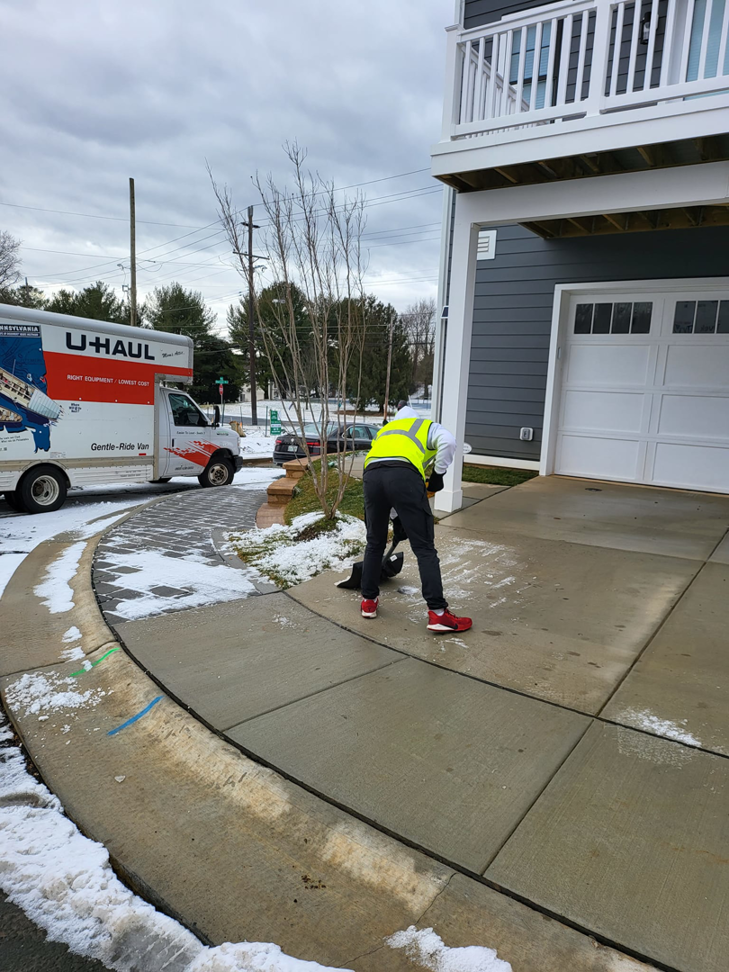 A worker shoveling snow from a residential sidewalk as part of snow removal services by American Snow Plowing Services in Rockville, MD.