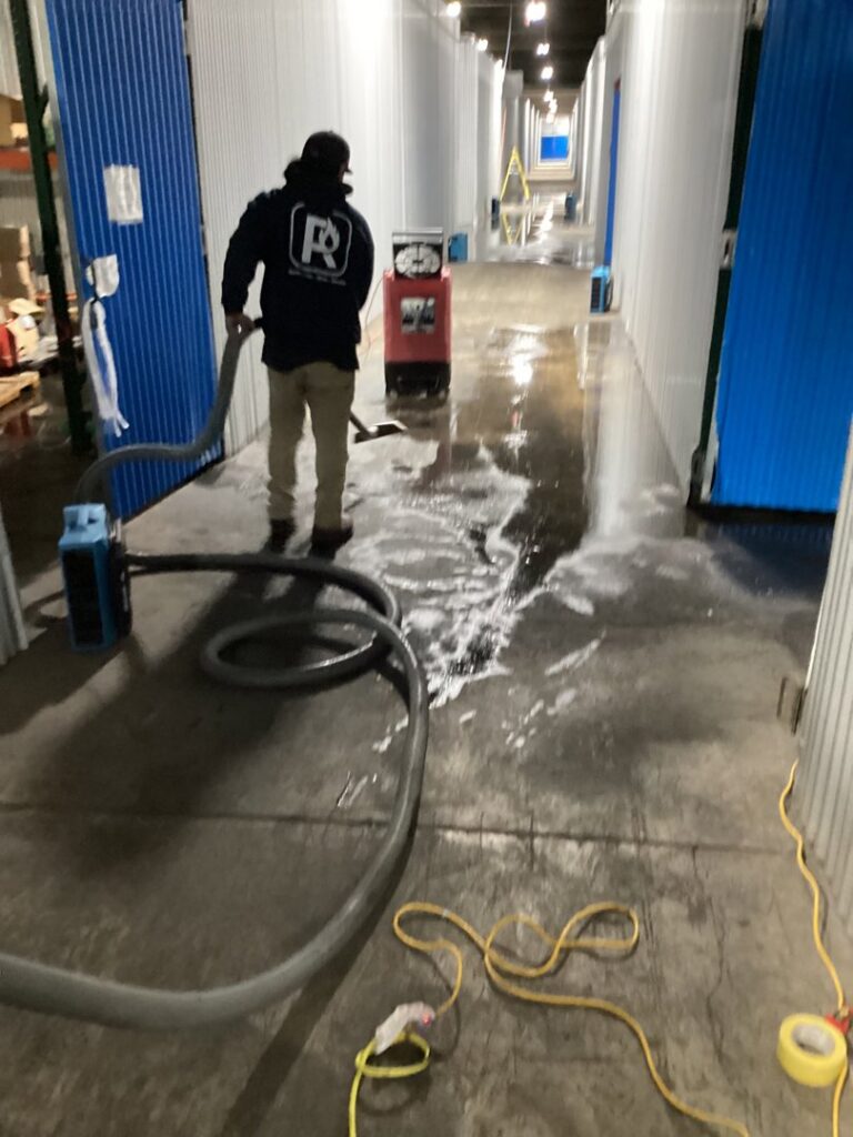 A worker performing water extraction on a commercial floor after water damage for RestoPros Hudson County in Jersey City, NJ.