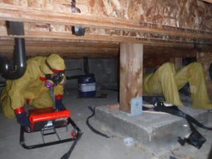 Workers in yellow hazmat suits performing remediation in a crawl space, a service by Central Oregon Disaster Restoration in Bend, OR.