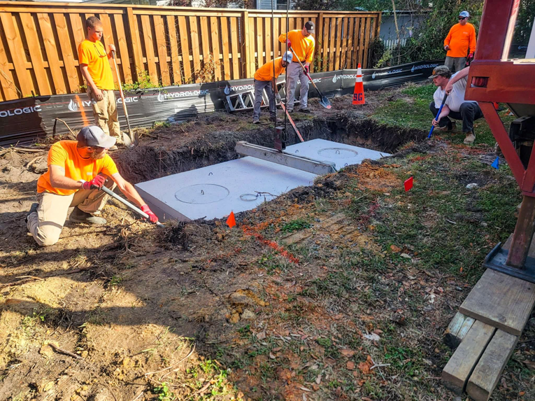 Workers installing concrete water management tanks for Gilbert + Lee Construction in Summerville, SC.