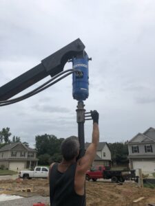 Workers installing exterior drainage and waterproofing membrane next to a house foundation by Stay Dry Waterproofing LLC in Marysville, OH.
