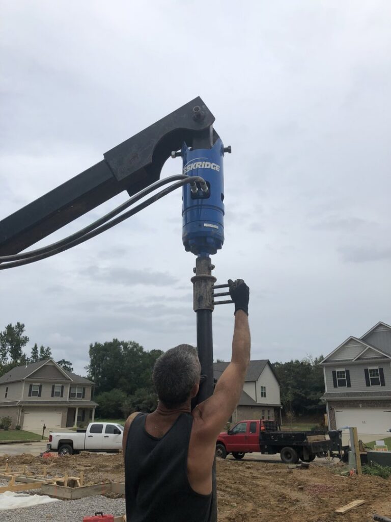 Workers installing exterior drainage and waterproofing membrane next to a house foundation by Stay Dry Waterproofing LLC in Marysville, OH.