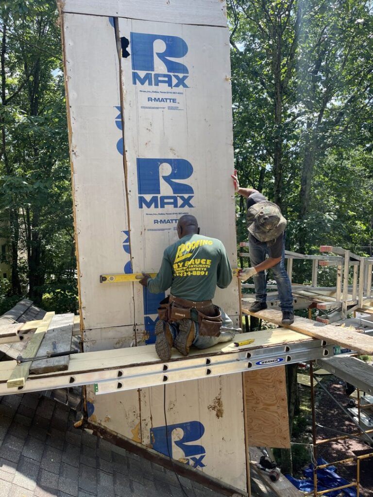 Workers installing R-MAX insulation boards on a chimney chase, part of exterior work by JHV Roofing in Scranton, PA.
