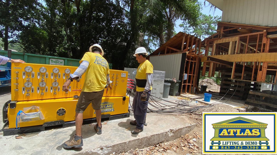 Atlas Lifting & Demo LLC workers operating hydraulic jacks for a house lifting project in Hilton Head Island, SC