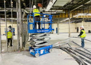 Workers on a lift removing ceiling grid during interior demolition by Orion Demolition & Environmental Services, LLC in Albany, NY.