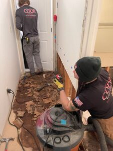 Workers removing water-damaged flooring and drywall, a service provided by Central Oregon Disaster Restoration in Bend, OR.