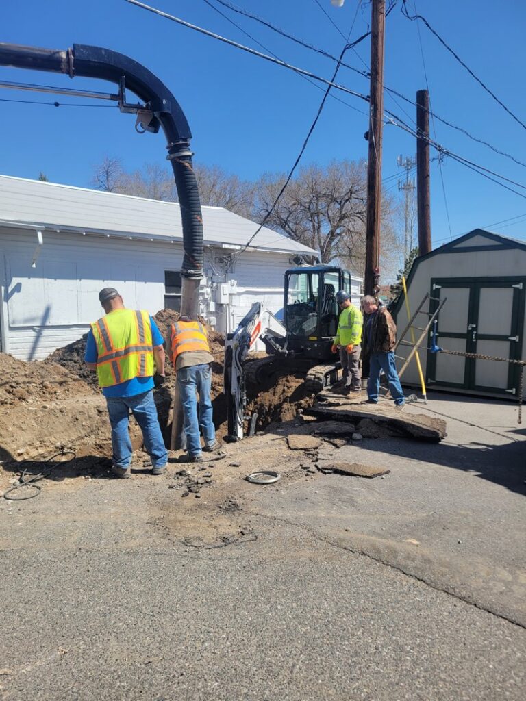 Workers repairing an underground water line with a vacuum excavator and mini excavator for B&M Septic and Excavation Services in Riverton, WY