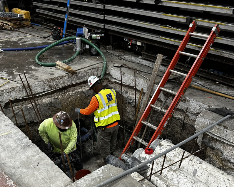 Workers in a trench performing drainage or foundation repair with a pump for Proshield Waterproofing & Restoration in Overland Park, KS