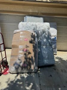 Wrapped boxes and mattresses on a driveway, ready for loading by Household Goods Moving and Storage in Rockville, MD