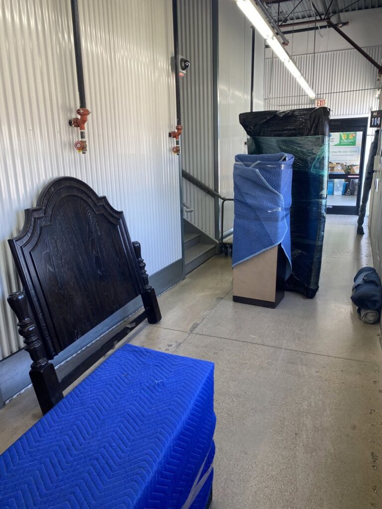 Wrapped furniture and a headboard in a hallway, ready for transport by Advantage Express Movers in Arlington, TX.