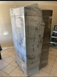 A large furniture item professionally wrapped in blankets and plastic by Fatboy Slims Moving Company in Colorado Springs, CO.