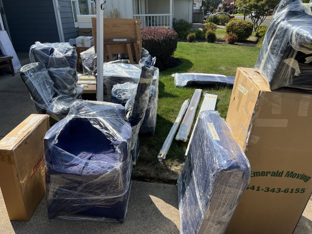 Professionally wrapped furniture and moving boxes from Emerald Moving & Storage, Inc. outside a home in Eugene, OR.
