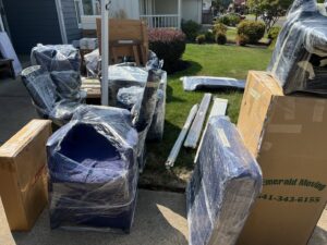 Professionally wrapped furniture and moving boxes from Emerald Moving & Storage, Inc. outside a home in Eugene, OR.