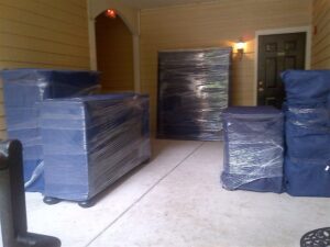 Wrapped furniture waiting outside an apartment for loading by Moving Pros LLC in Surprise, AZ.