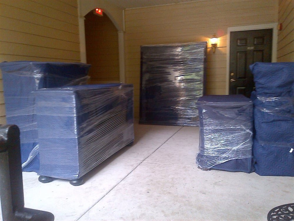 Wrapped furniture waiting outside an apartment for loading by Moving Pros LLC in Surprise, AZ.
