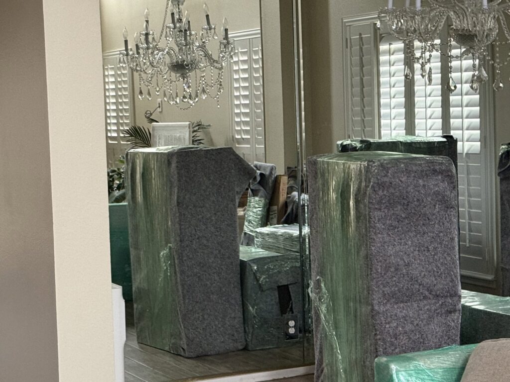Furniture wrapped in protective blankets and plastic, ready for moving by Packsen Moving in San Antonio, TX.