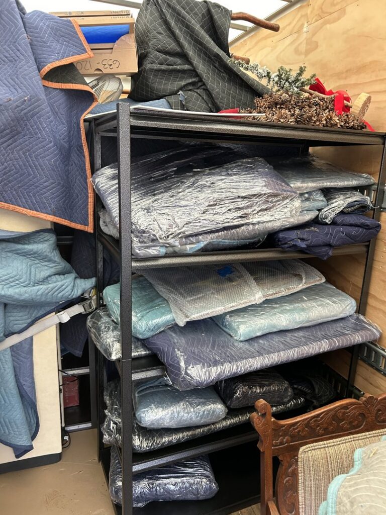 Wrapped items and moving blankets neatly arranged on shelves inside a Next Step Moving truck in Eau Claire, WI.