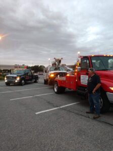 A black wrecker tow truck from Hank's Auto Service towing a purple sedan in Bethlehem, PA.
