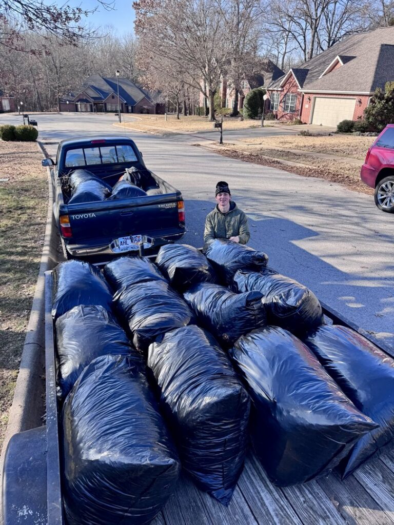 A trailer filled with black bags of yard waste for removal by All in- Landscaping and Power-washing in Fayetteville, AR.