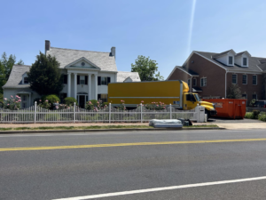 A yellow moving truck parked in front of a house, ready for a job by Monty's Movers in Fairfax, VA.
