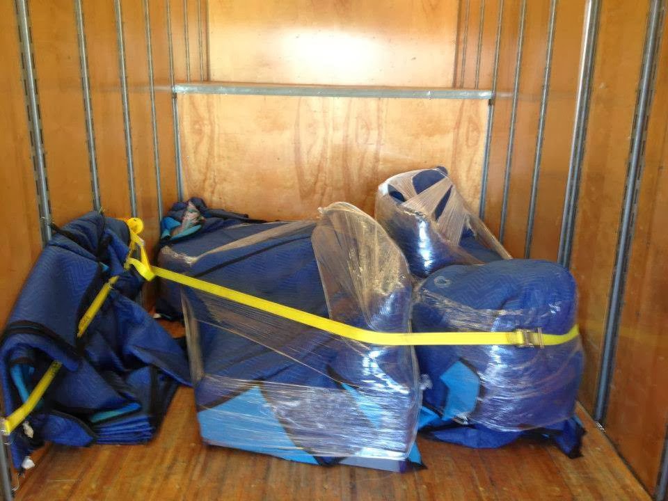 Wrapped furniture and moving blankets secured inside a Your Friends - Moving Services truck in Lansing, MI.